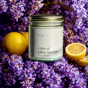 A Ray of Effing Sunshine candle surrounded by lemons and lilac to indicate the fragrance notes of the candle
